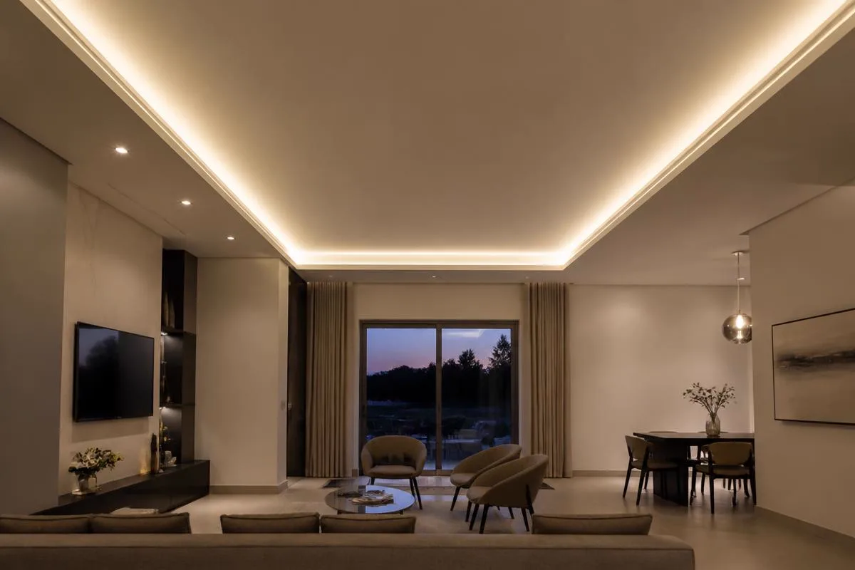 Velette in cartongesso con gole luminose e strip LED che illuminano un soggiorno moderno
